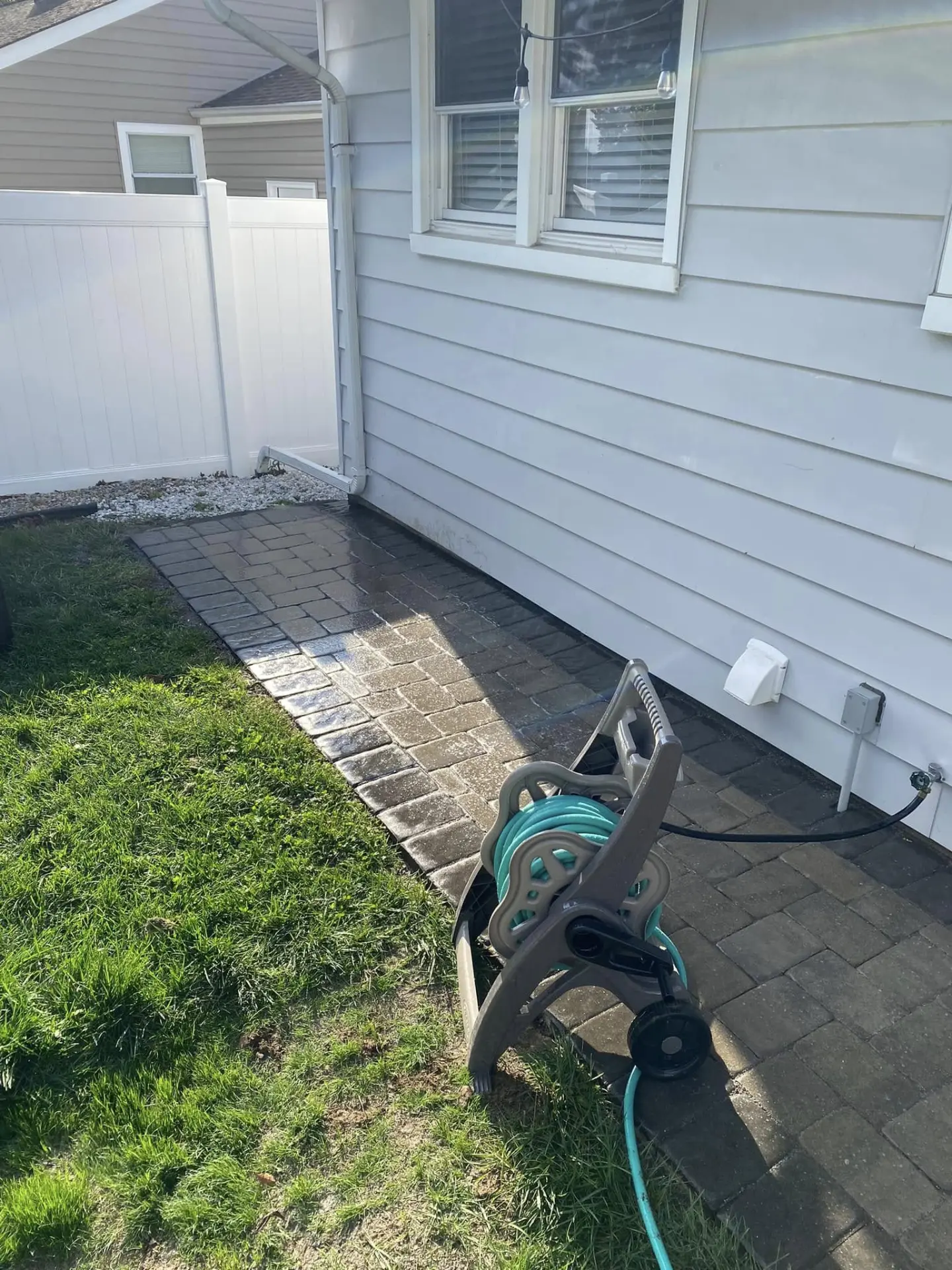 Paver pad and walkway along the side of a home with fresh grass