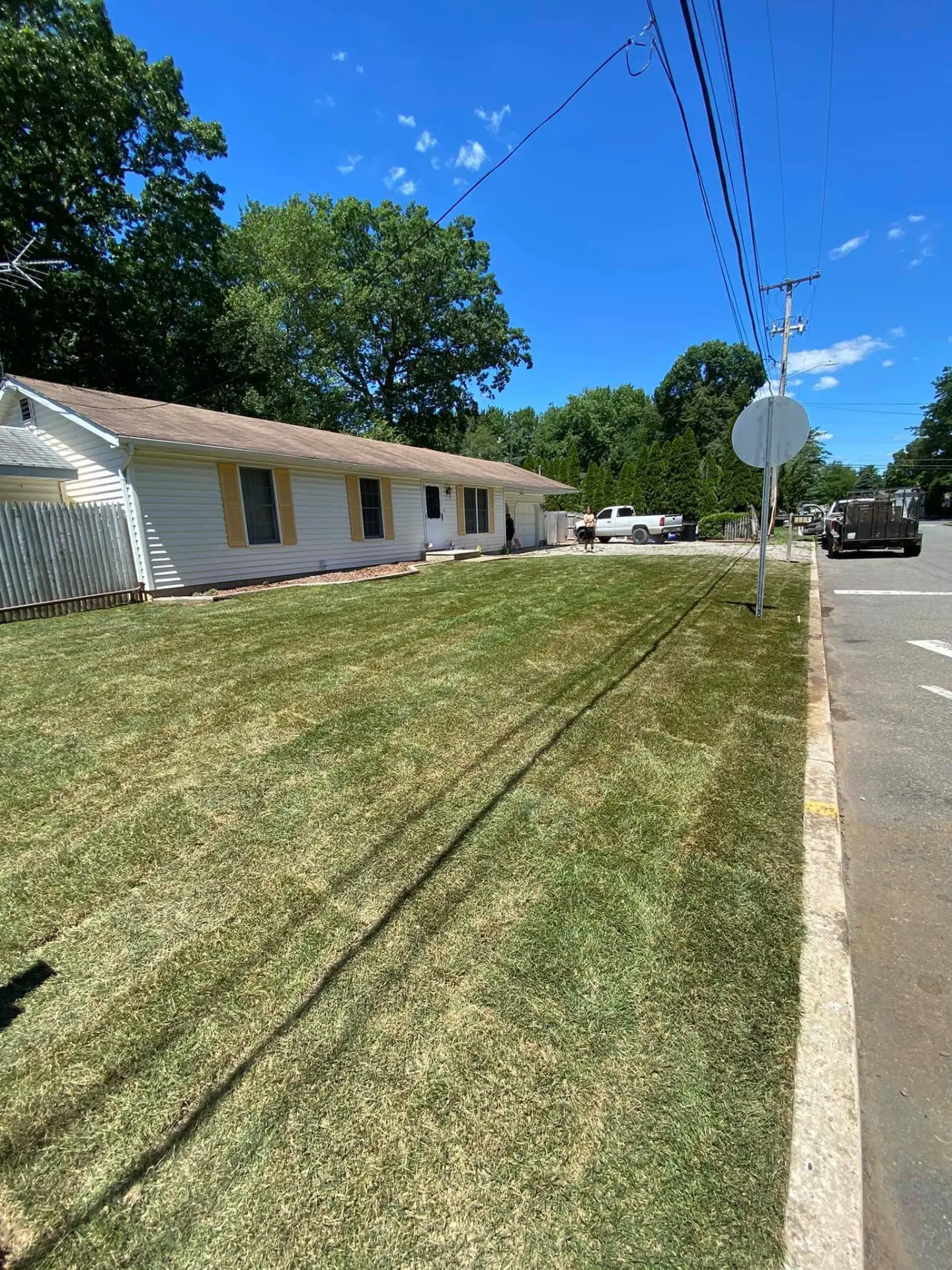 Freshly laid sod covering a front lawn beside a ranch home