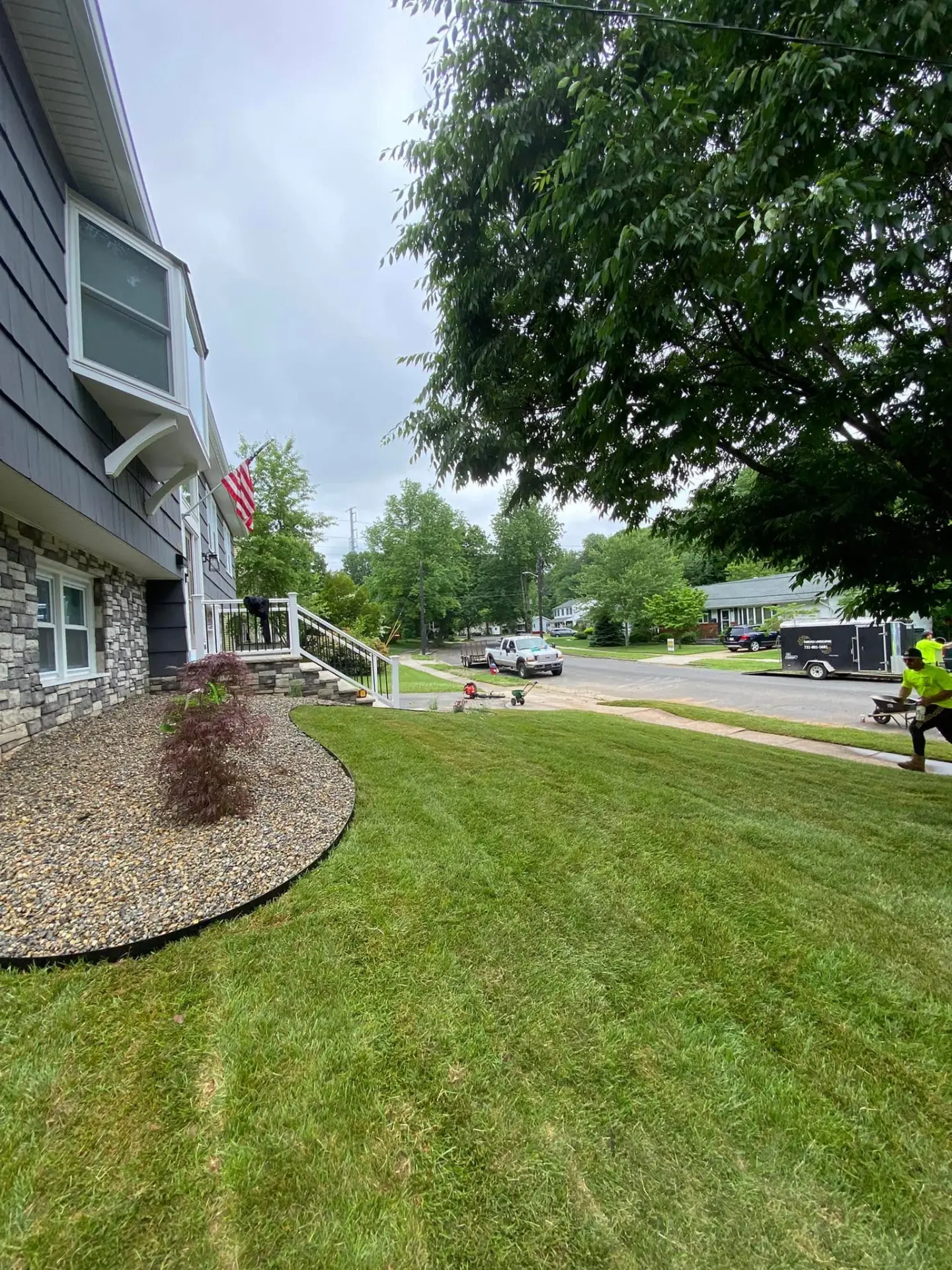 Finished front lawn with river rock beds along a home